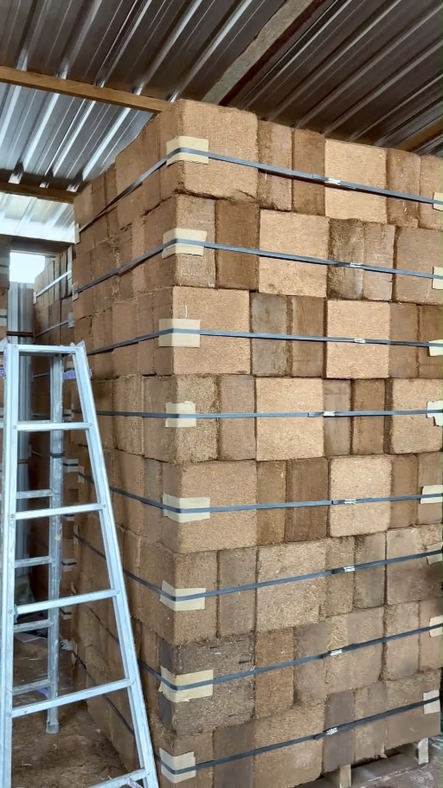 Compressed cocopeat blocks stacked and strapped in storage